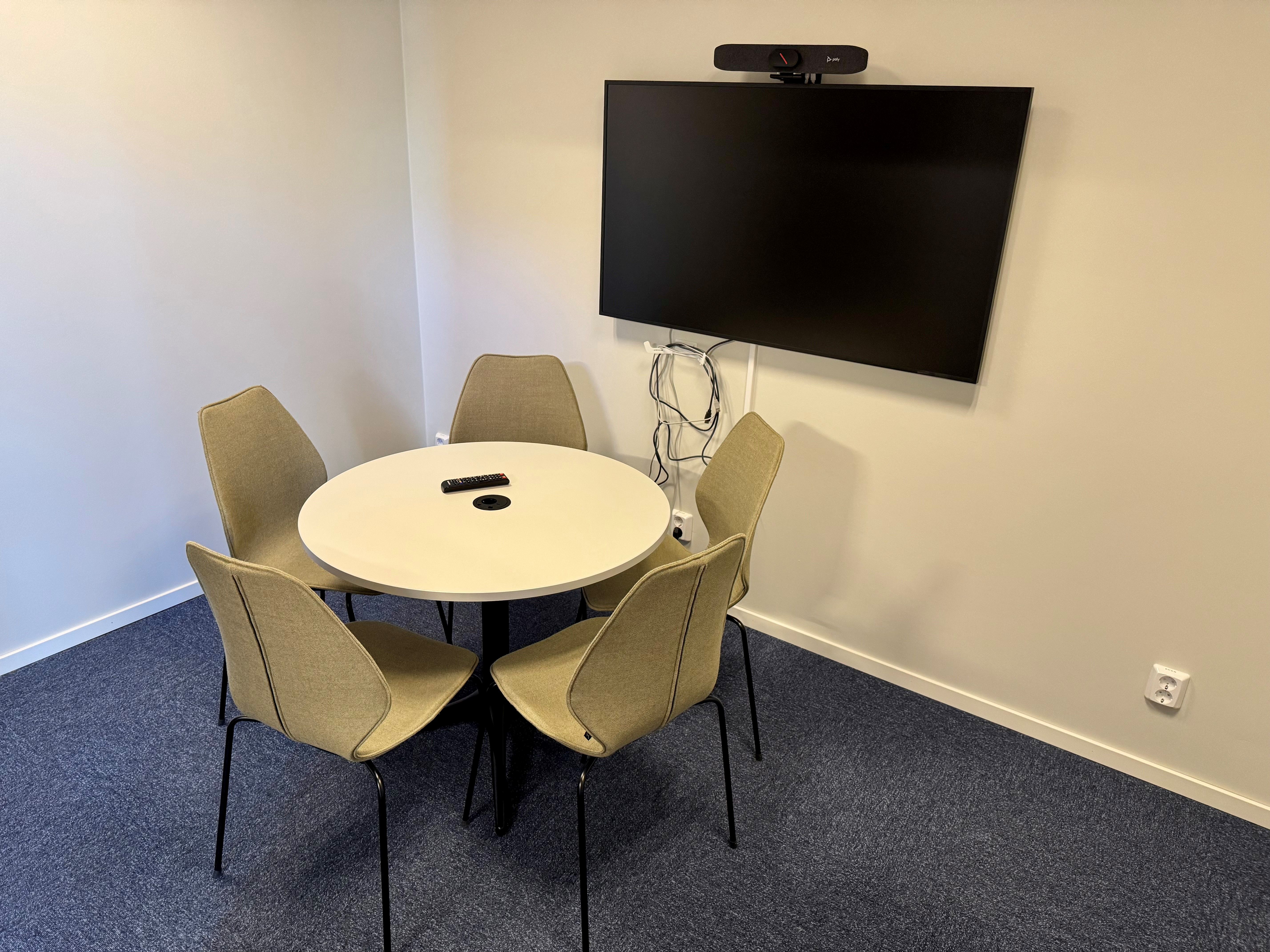 Studio med plats för fem personer, med runt bord och distansteknik